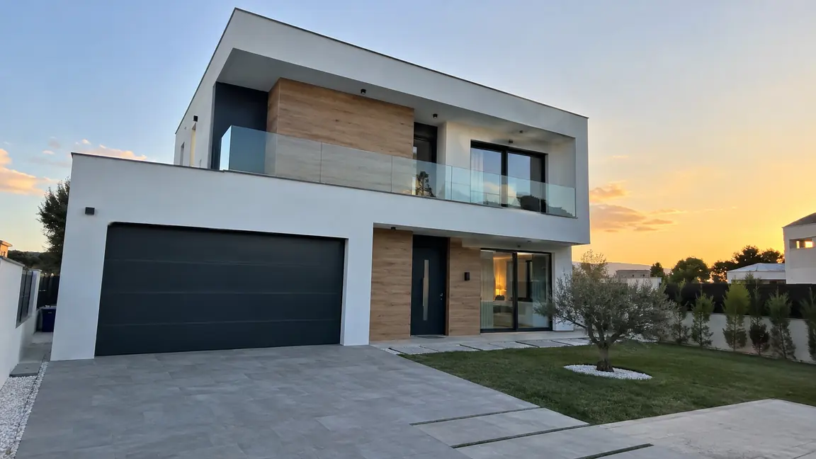 Vivienda unifamiliar de dos plantas terminada por Reformas DLCP, con fachada blanca, revestimiento de madera, barandilla de vidrio y porche de garaje